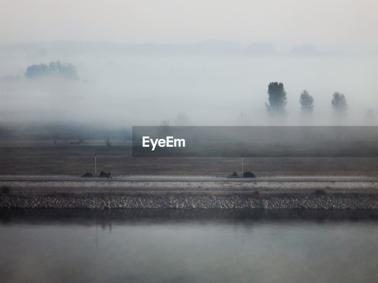 Scenic view of a river against sky in foggy weather