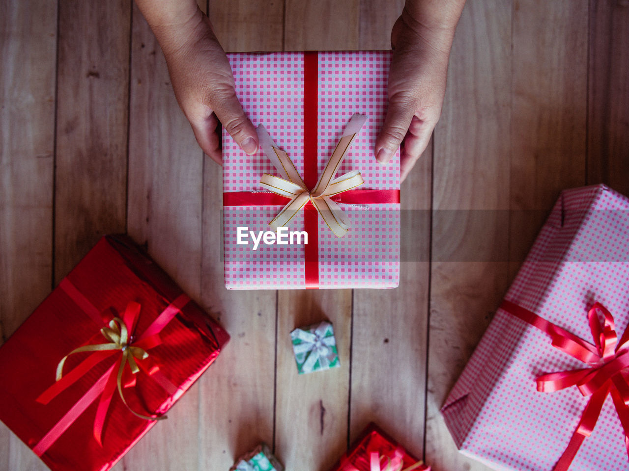 Cropped hand of person holding gift on table