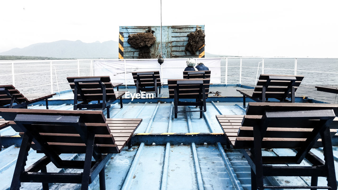 CHAIRS AND TABLES AGAINST SEA