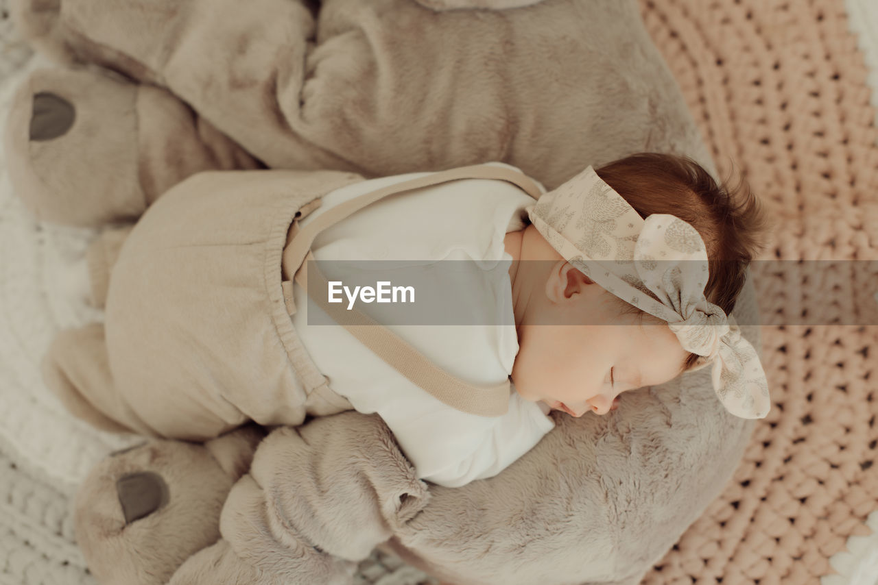 Cute baby girl sleeping on bed at home