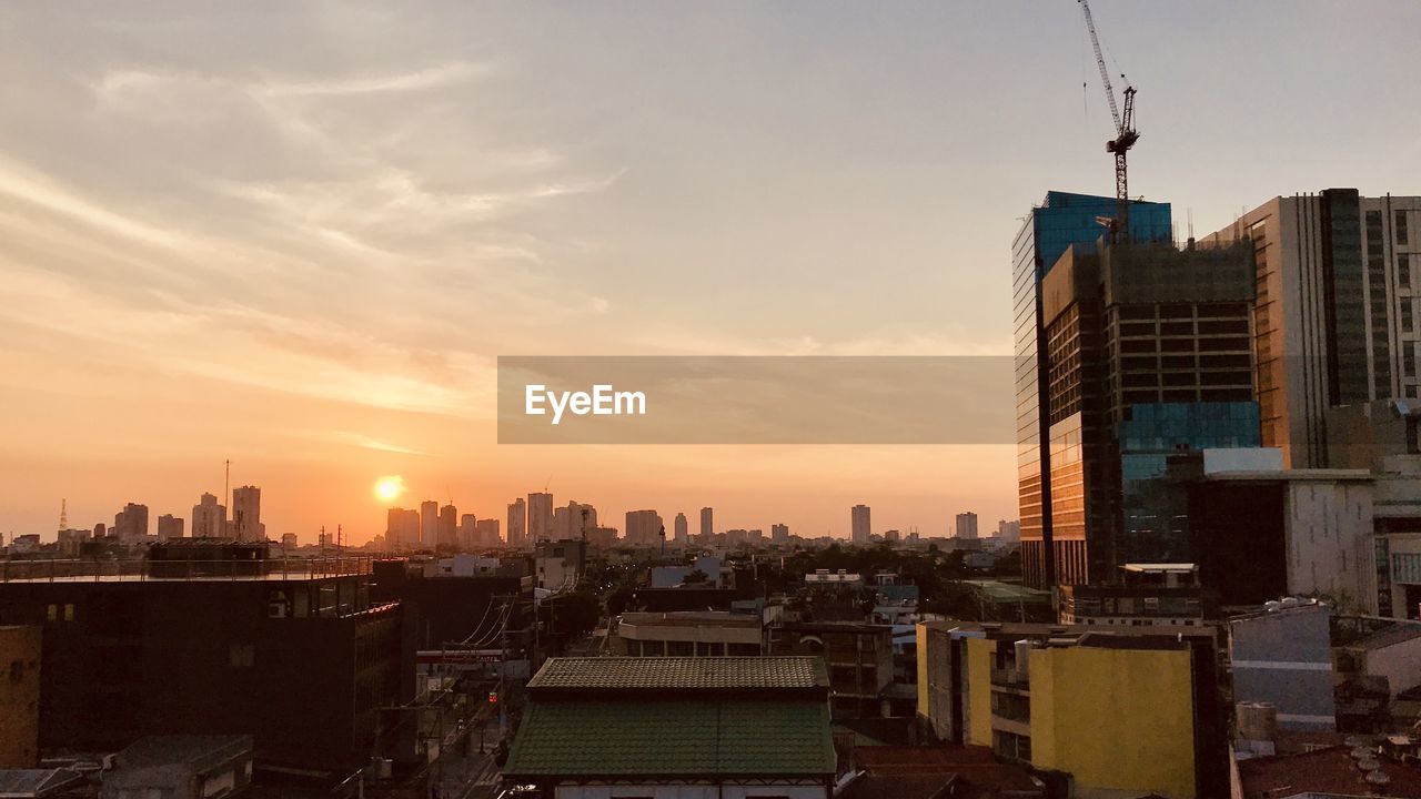 Modern buildings against sky during sunset