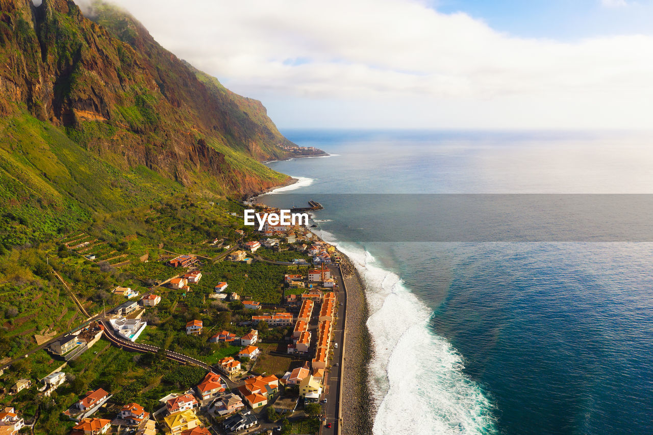 high angle view of city by sea against sky