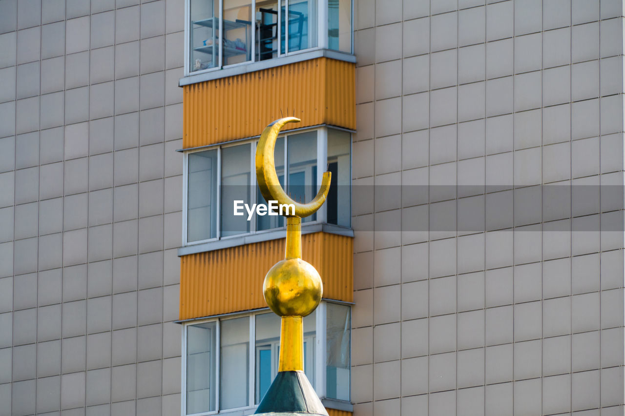 LOW ANGLE VIEW OF YELLOW GLASS BUILDING