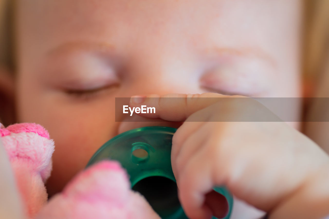 Close-up of baby girl sleeping with pacifier