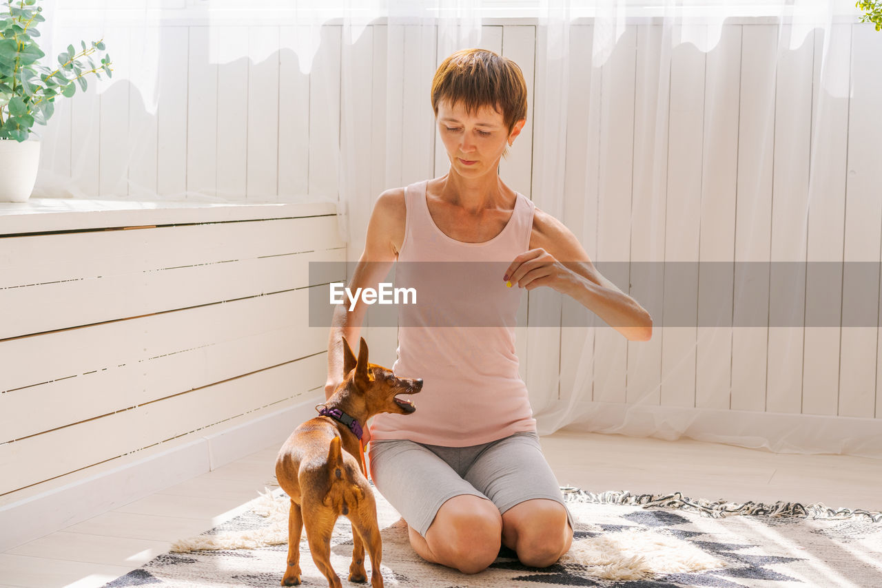 Woman practicing exercising with dog to enjoying and relaxing with yoga. spend