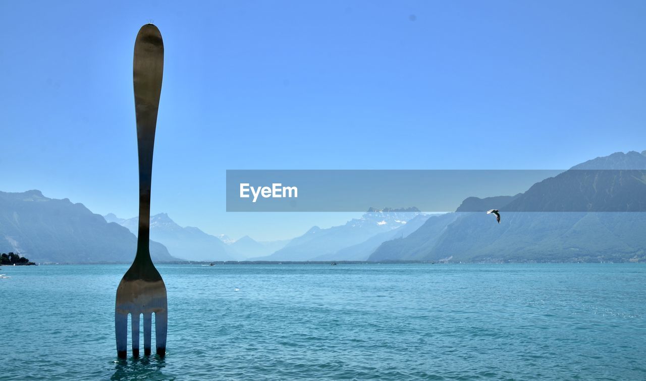 SCENIC VIEW OF SEA AGAINST MOUNTAINS