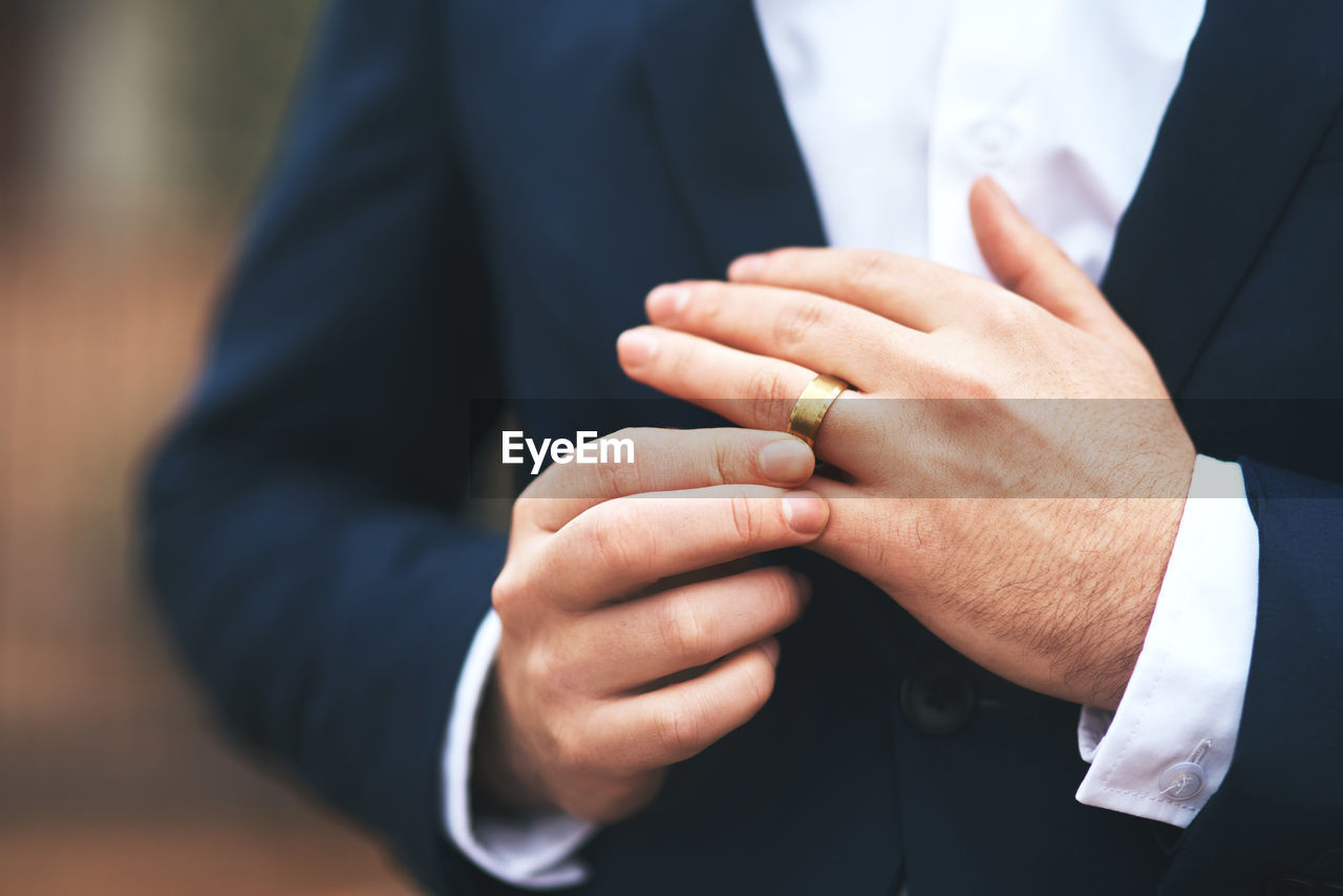 Midsection of man wearing ring