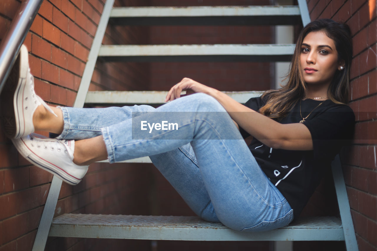 Portrait of beautiful young woman sitting on stairs