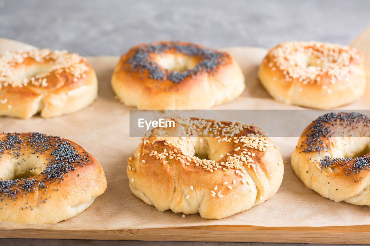 Baked bagels with poppy seeds and sesame seeds on parchment on the table. homemade pastries
