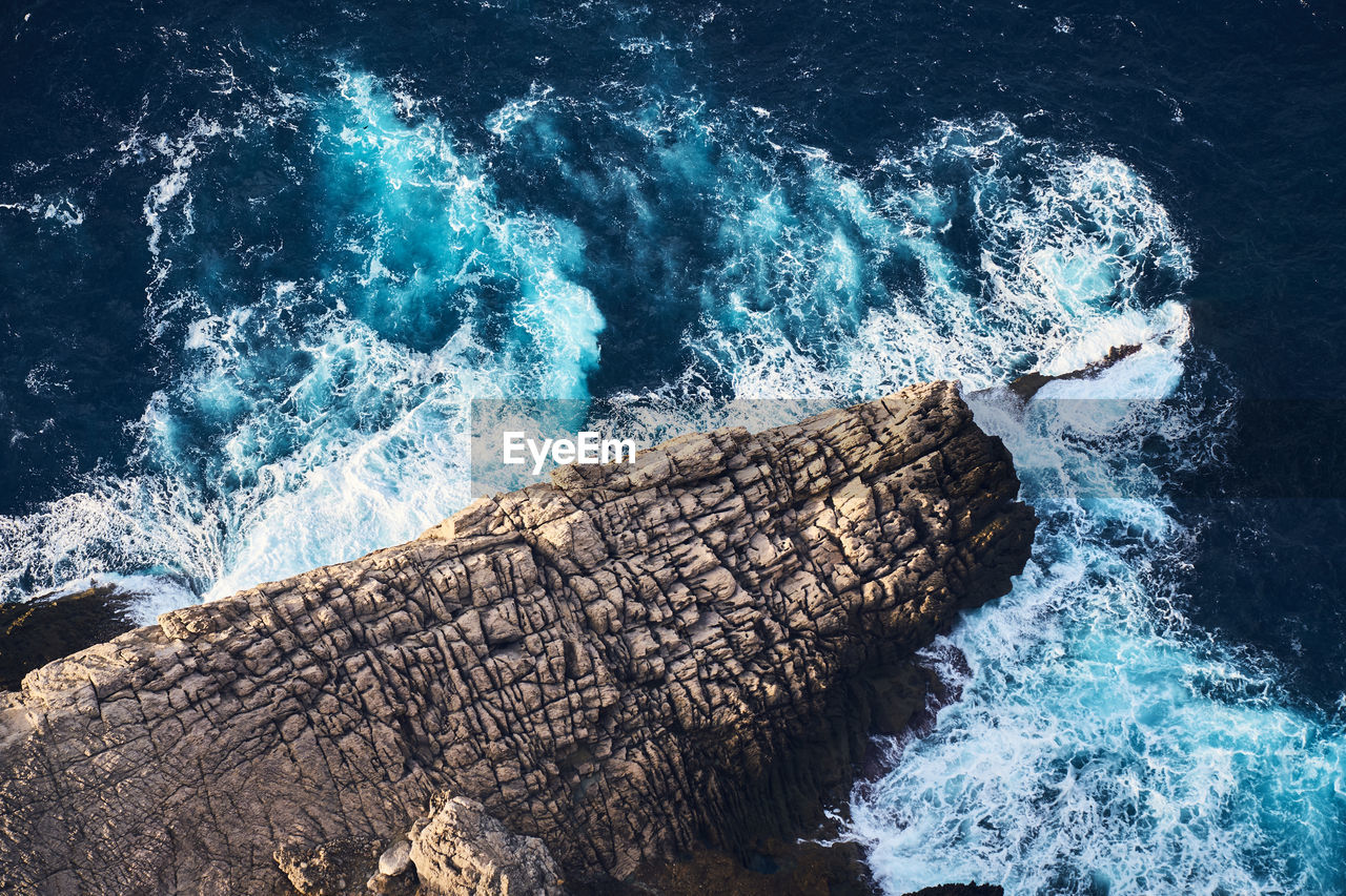 HIGH ANGLE VIEW OF WAVES SPLASHING WATER