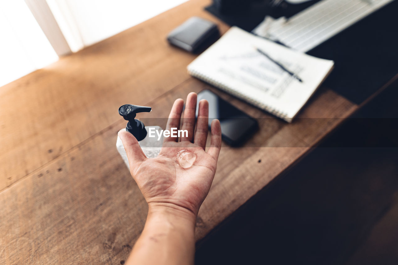 High angle view of woman hand on table