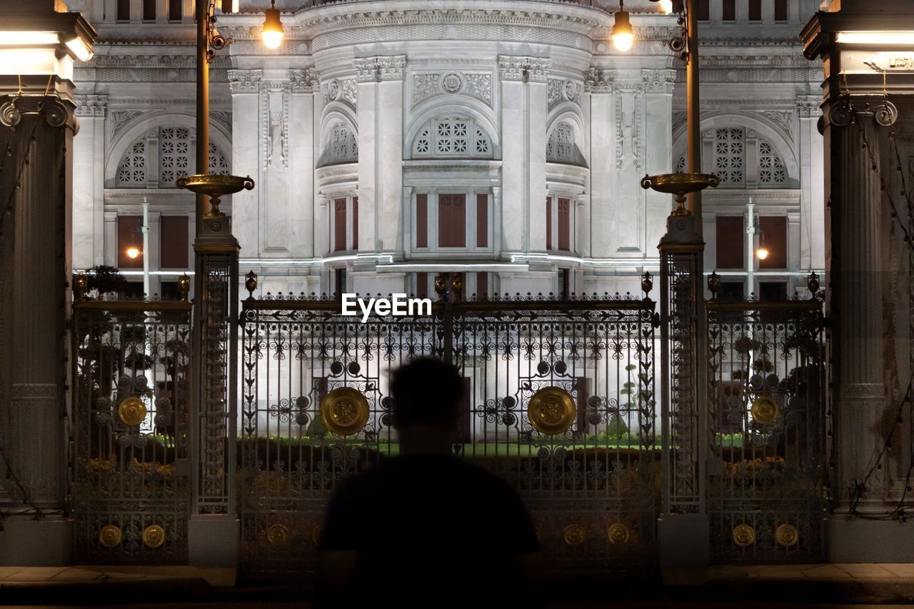 Rear view silhouette of a man standing in front of parliament building