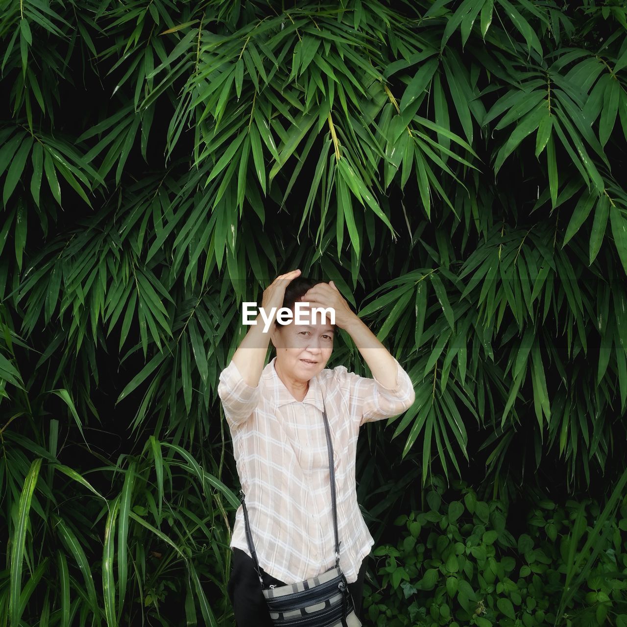 Portrait of woman standing against trees