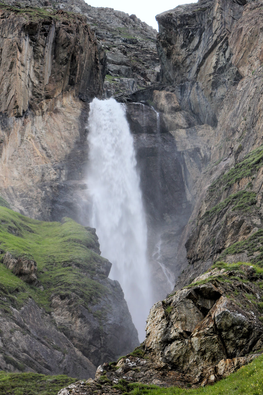 VIEW OF WATERFALL WITH ROCKS IN BACKGROUND