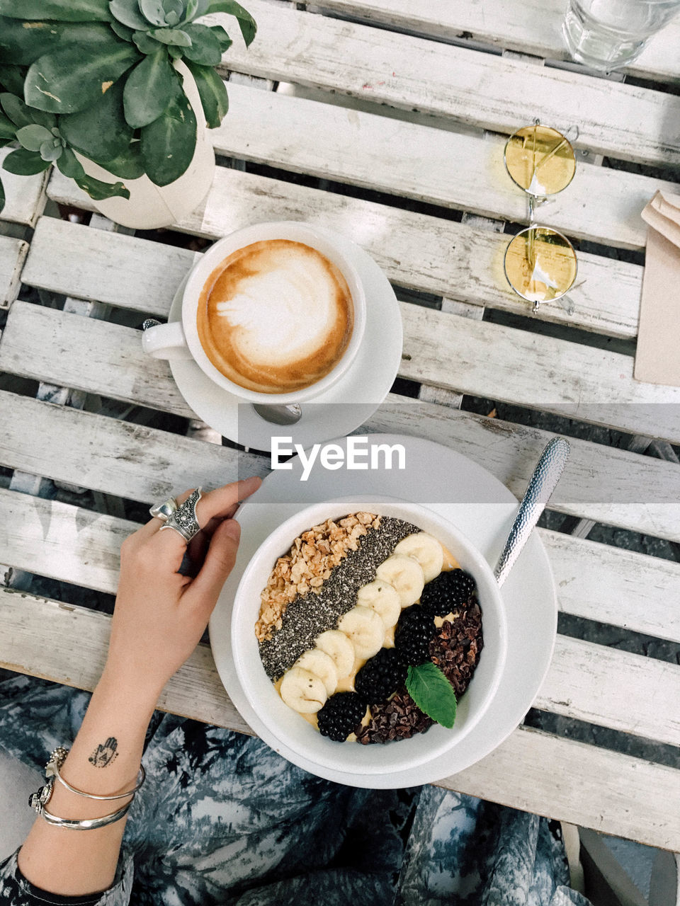 High angle view of woman holding coffee cup on table