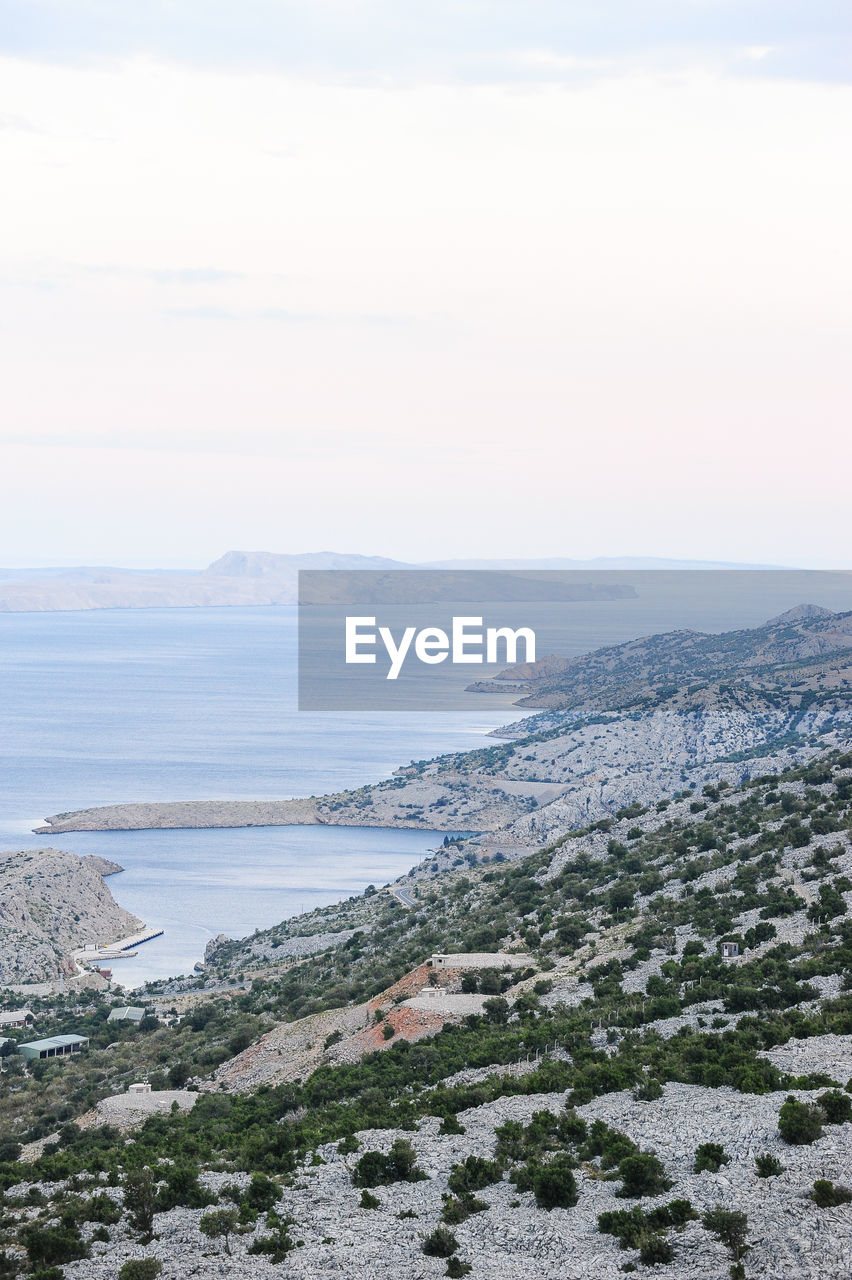 HIGH ANGLE VIEW OF SEA AND MOUNTAINS AGAINST SKY