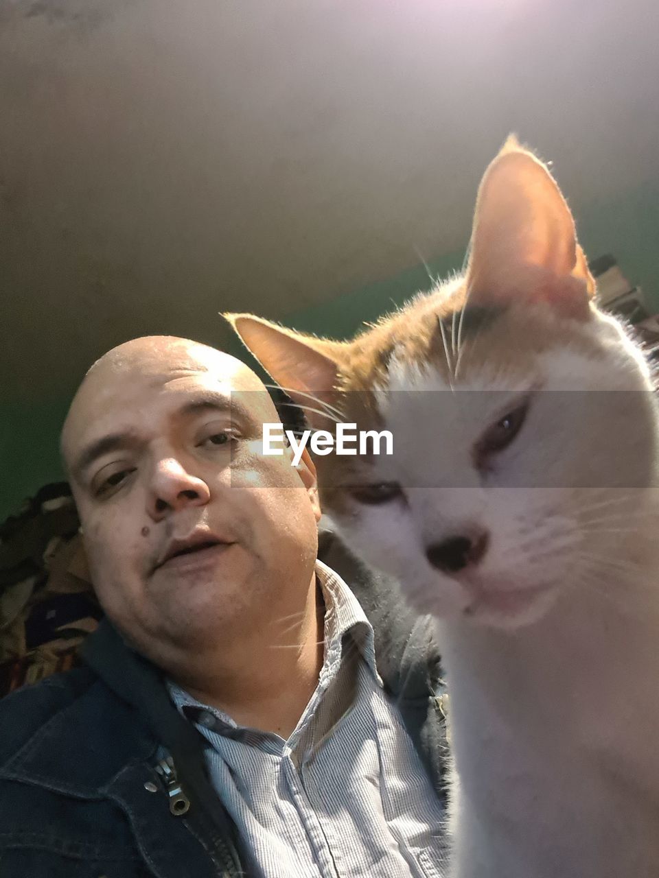 PORTRAIT OF MAN WITH CAT AGAINST WHITE BACKGROUND