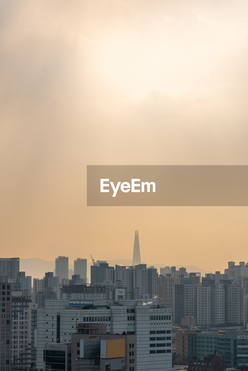 cityscape against cloudy sky during sunset