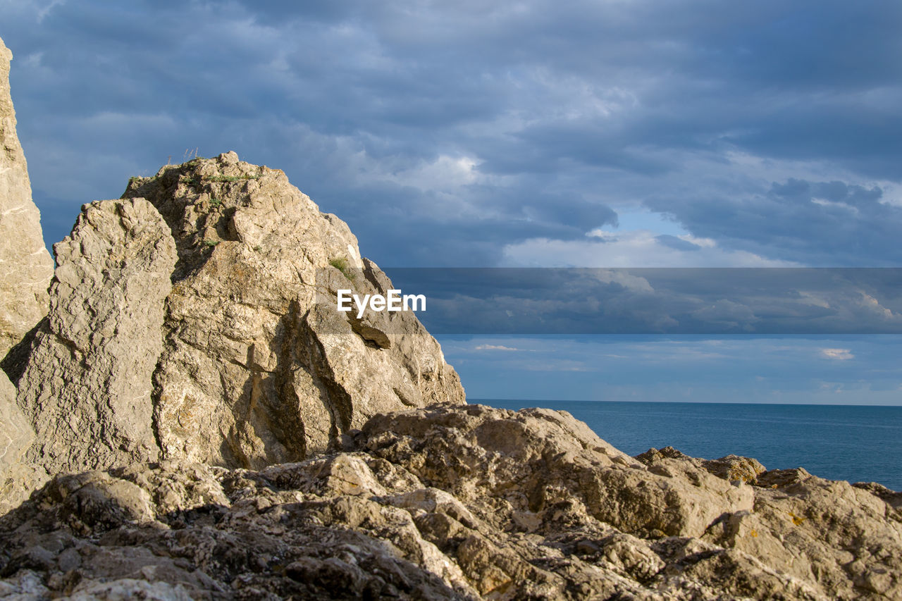 Rock formations by sea against sky