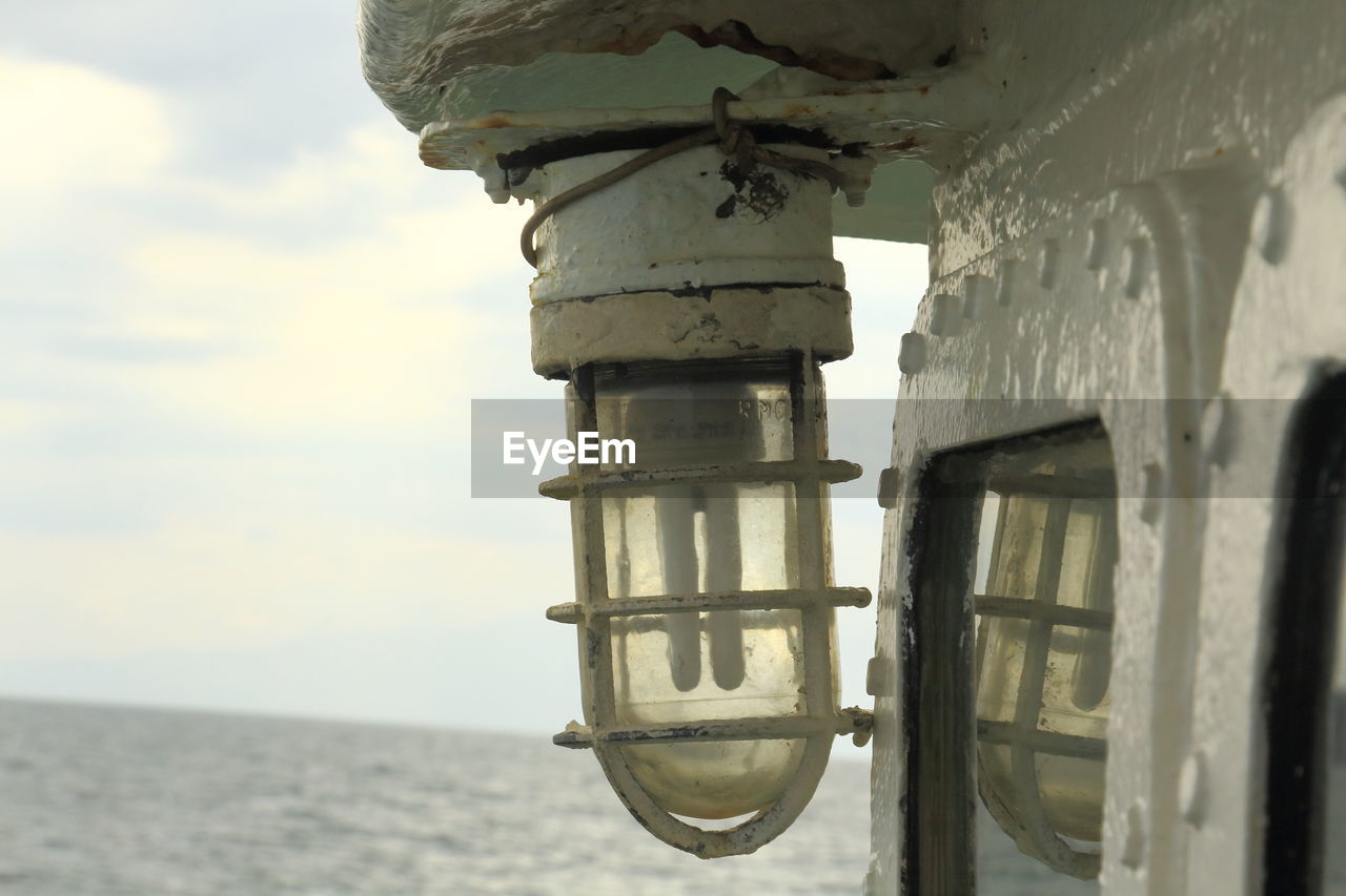 Close-up of light bulb on boat against sky