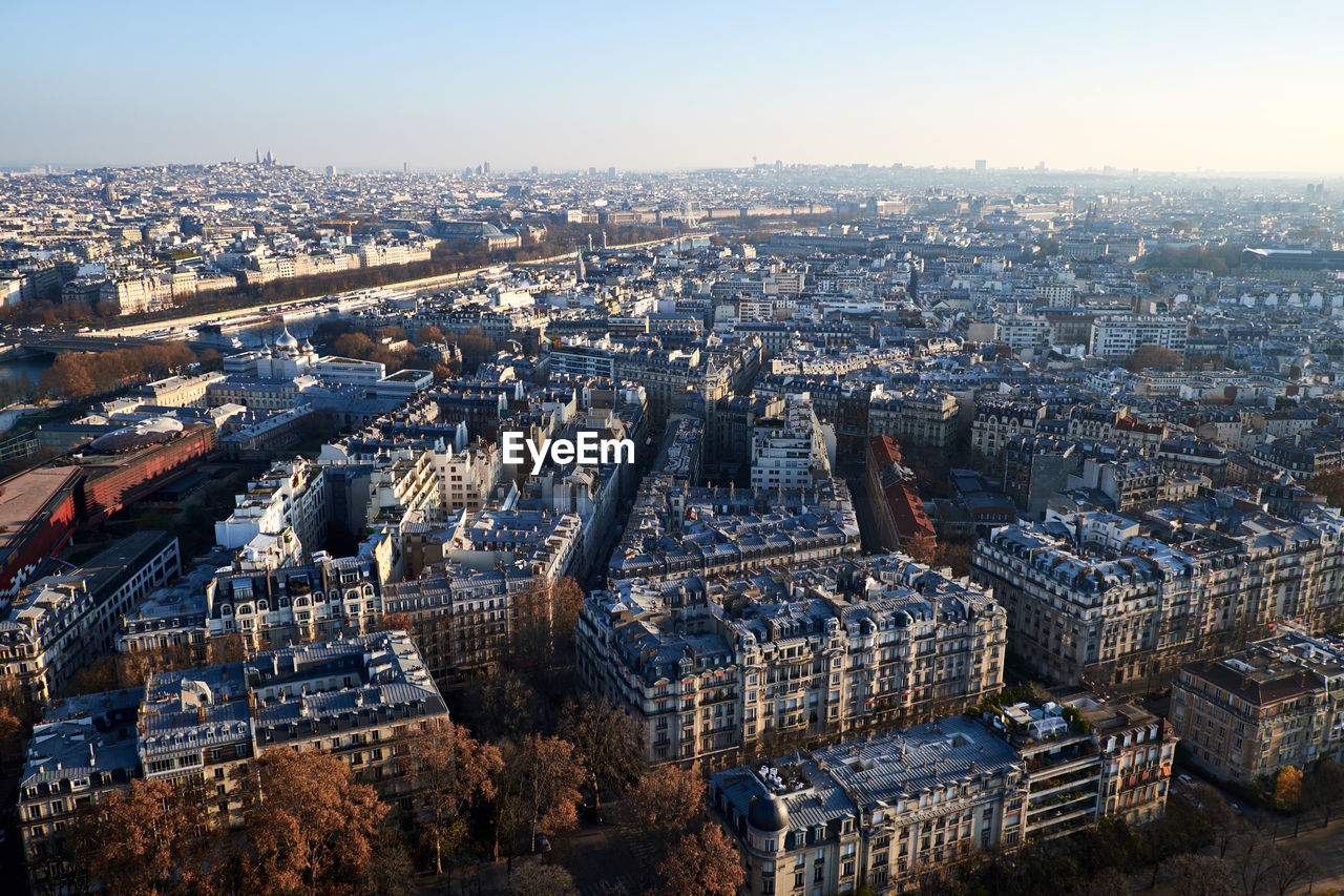 Aerial view of cityscape on sunny day against sky