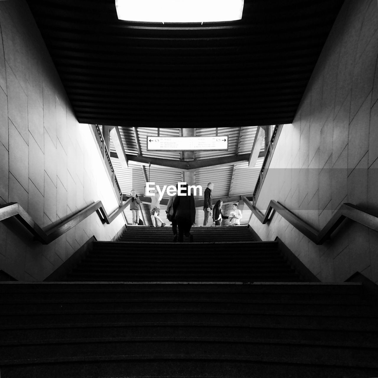 Low angle view of people moving up stairway at subway station
