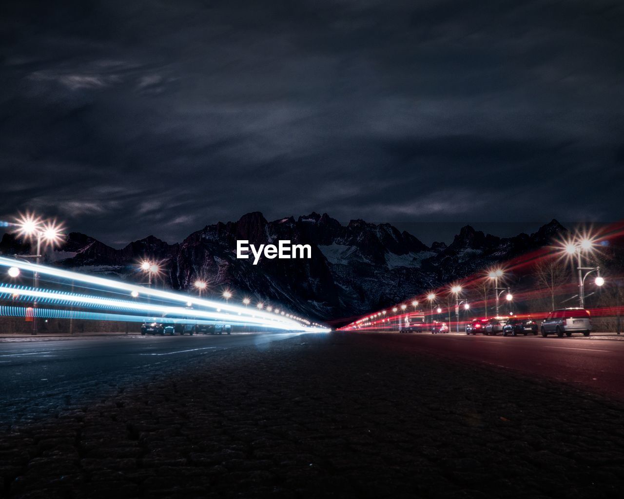 Light trails on road against sky at night