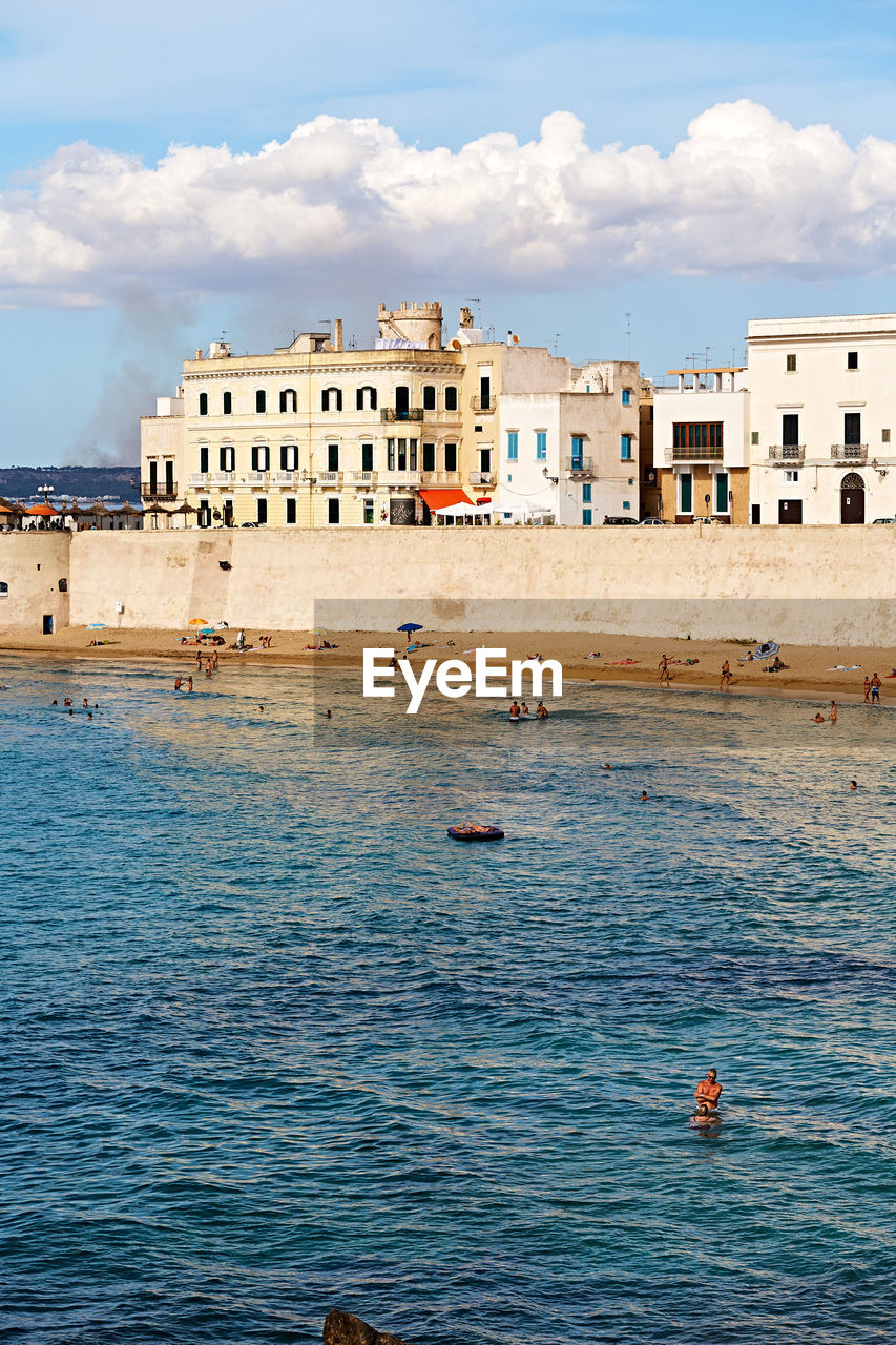 BUILDINGS ON SEA AGAINST SKY