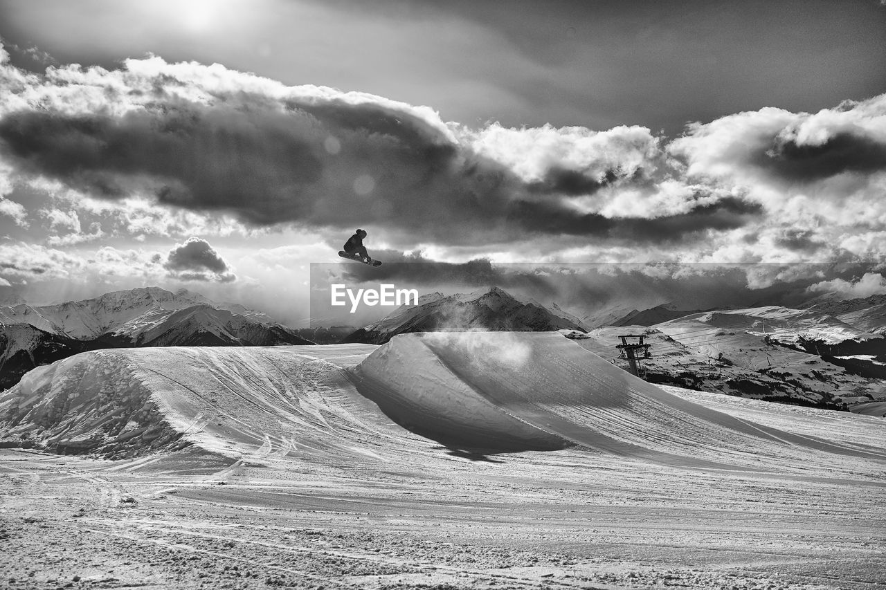 Man snowboarding against sky