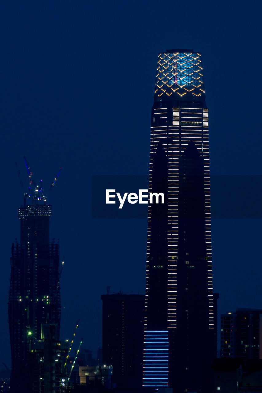 Low angle view of illuminated buildings against sky at night