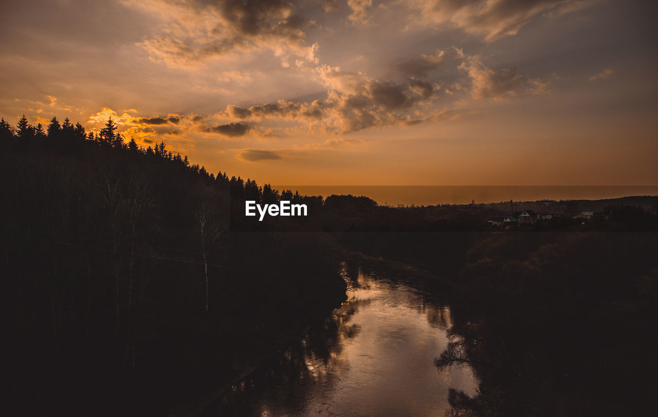 Scenic view of river against sky during sunset