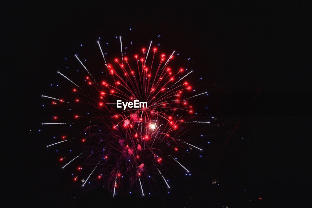 Low angle view of firework display against sky at night