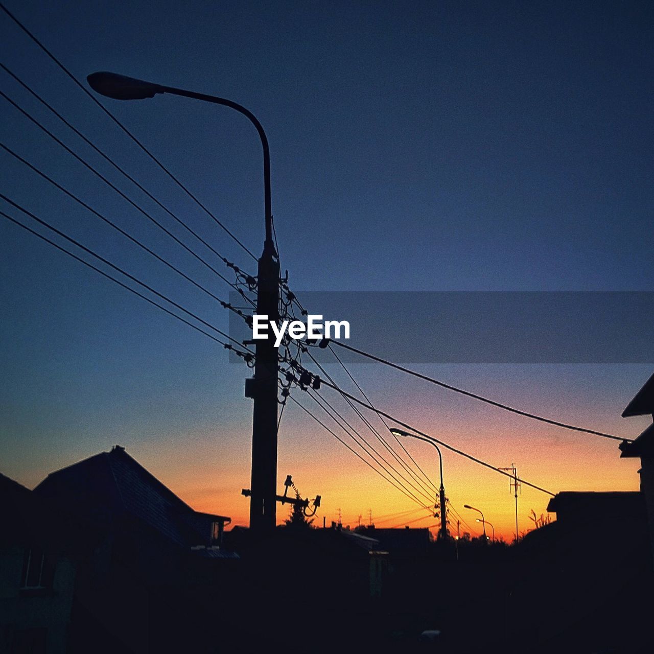 LOW ANGLE VIEW OF SILHOUETTE ELECTRICITY PYLONS AGAINST SKY