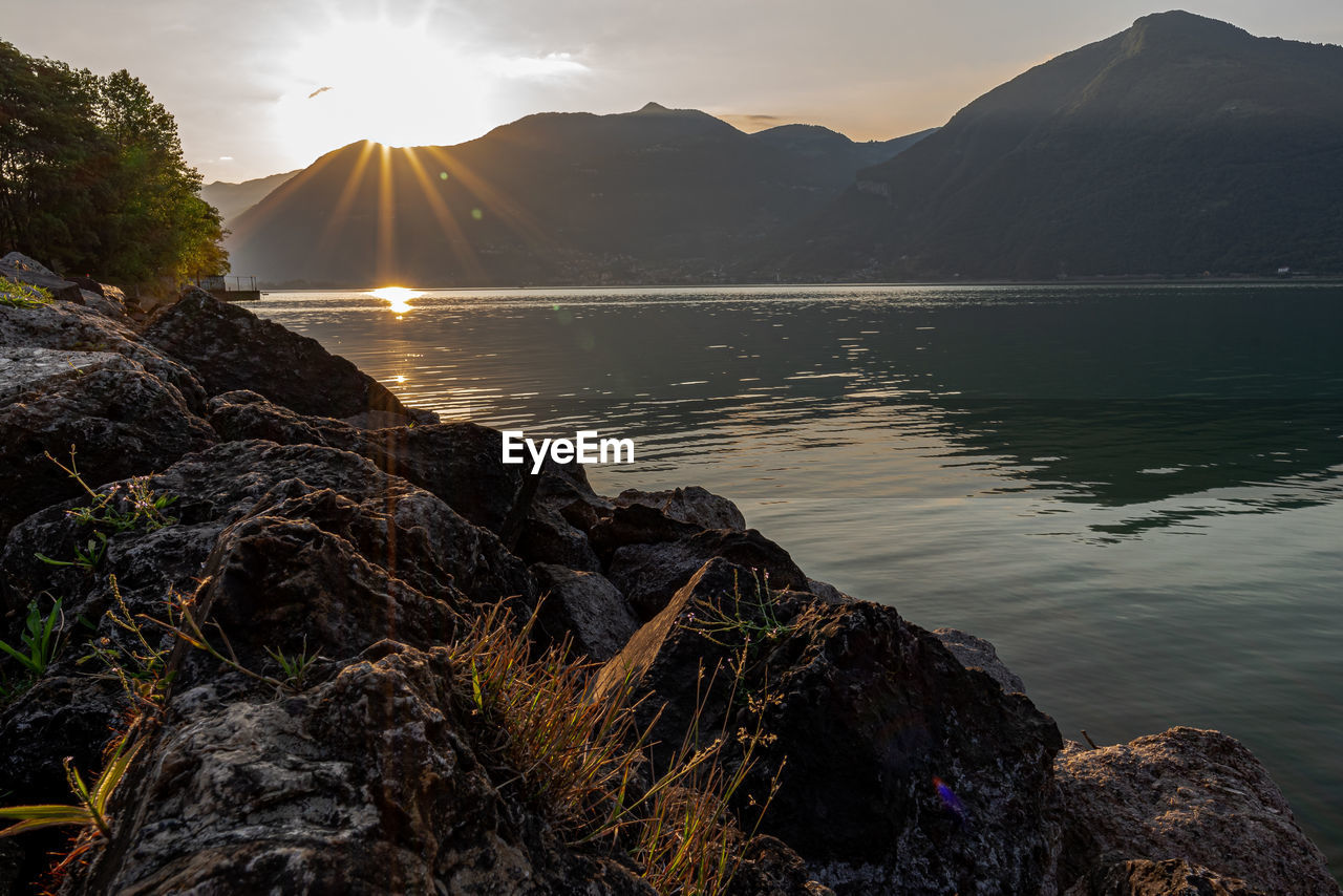 Scenic view of lake against mountains during sunset