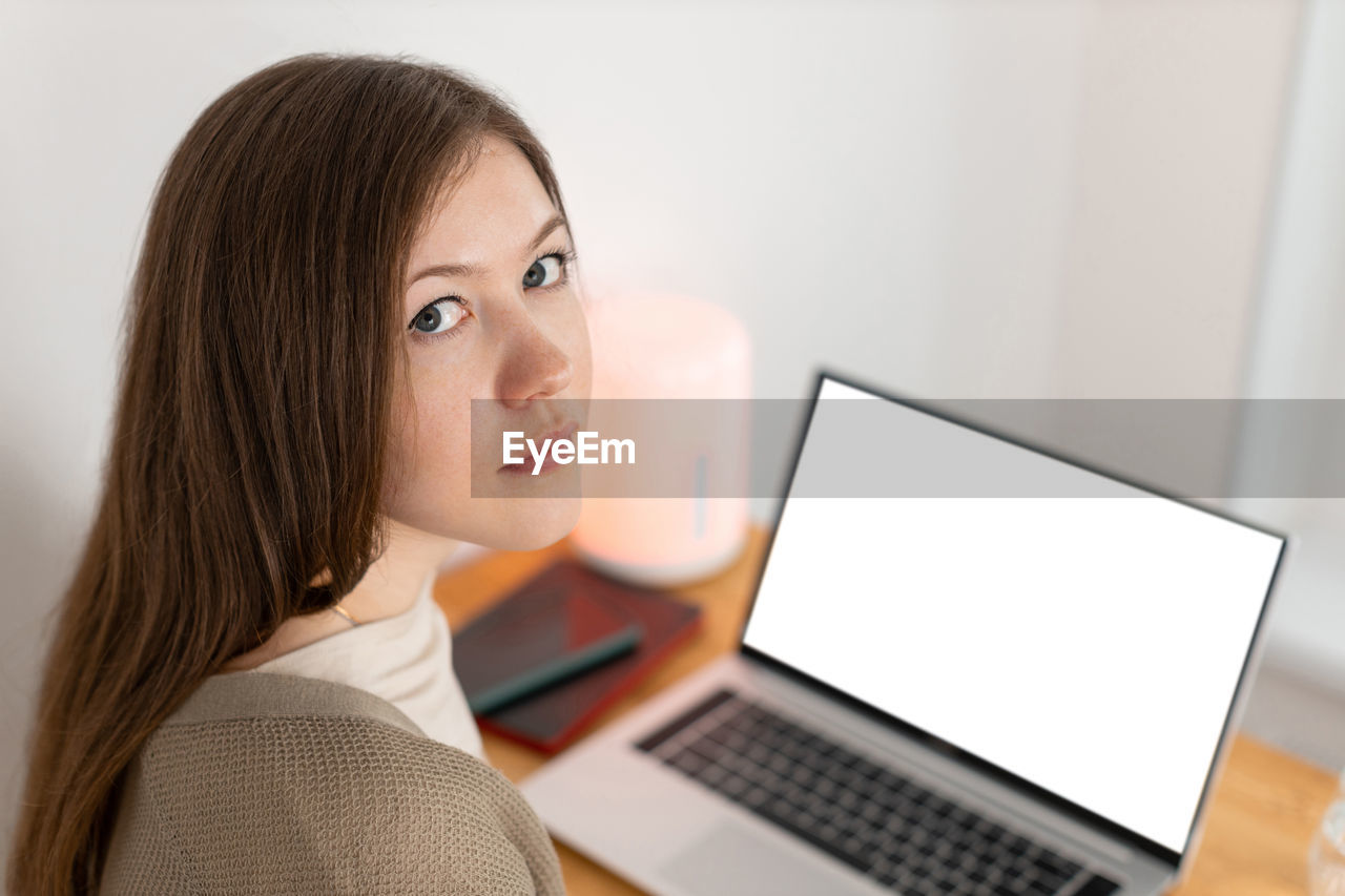 Pretty girl tired of working at computer. working from home office. woman looking into camera.