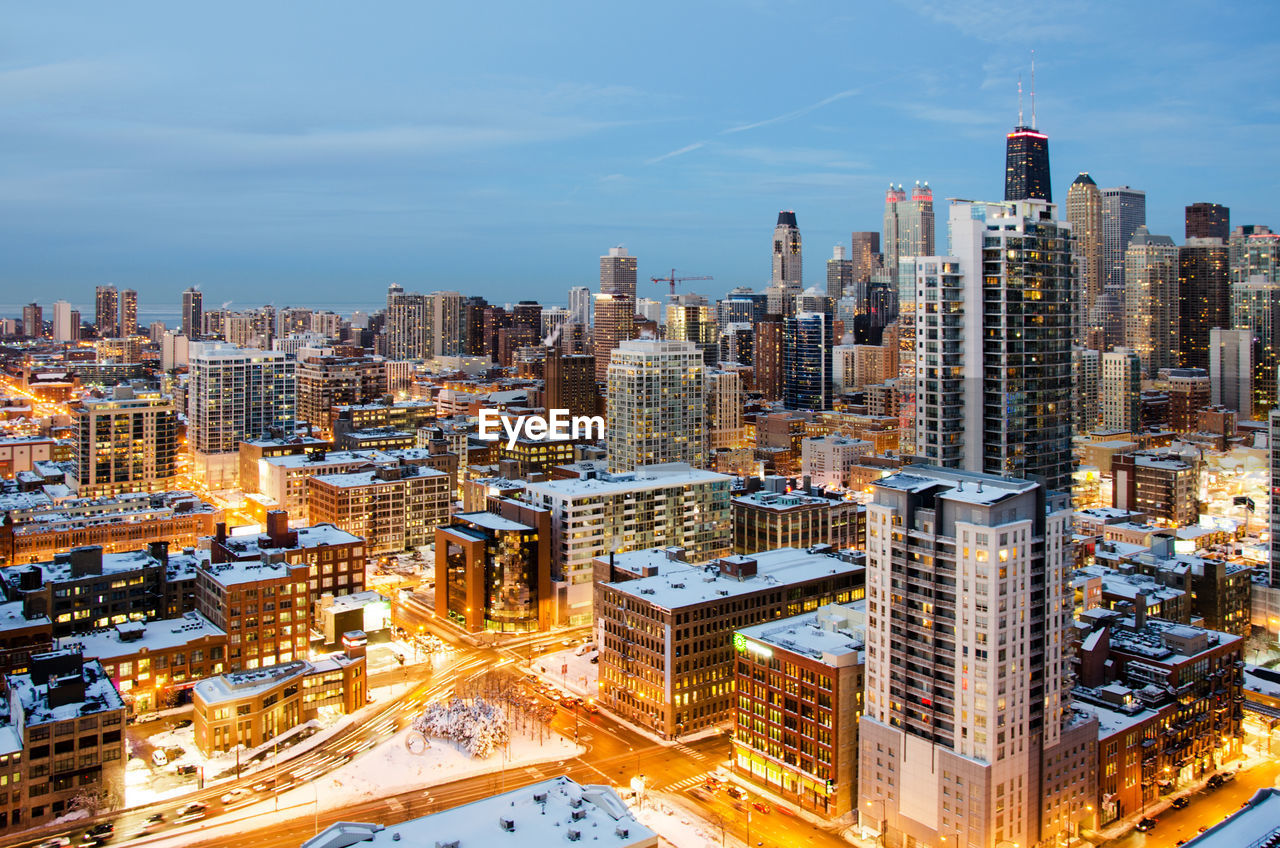 Illuminated cityscape during winter against sky