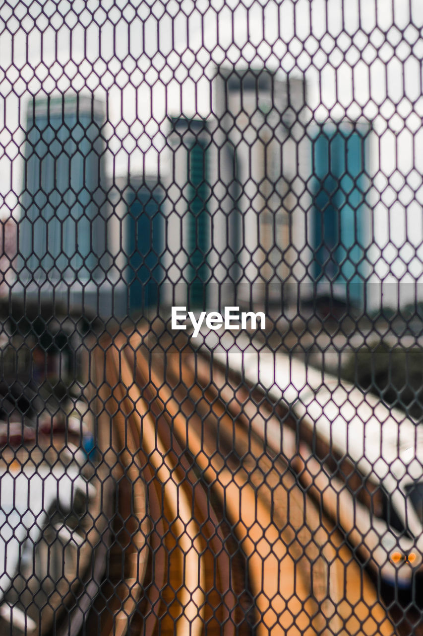 FULL FRAME SHOT OF CHAINLINK FENCE WITH METAL CHAIN IN BACKGROUND