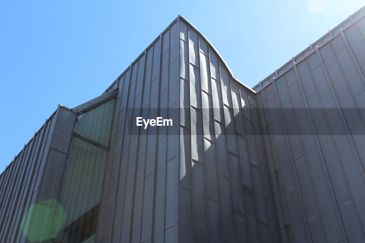 Low angle view of modern building against clear blue sky