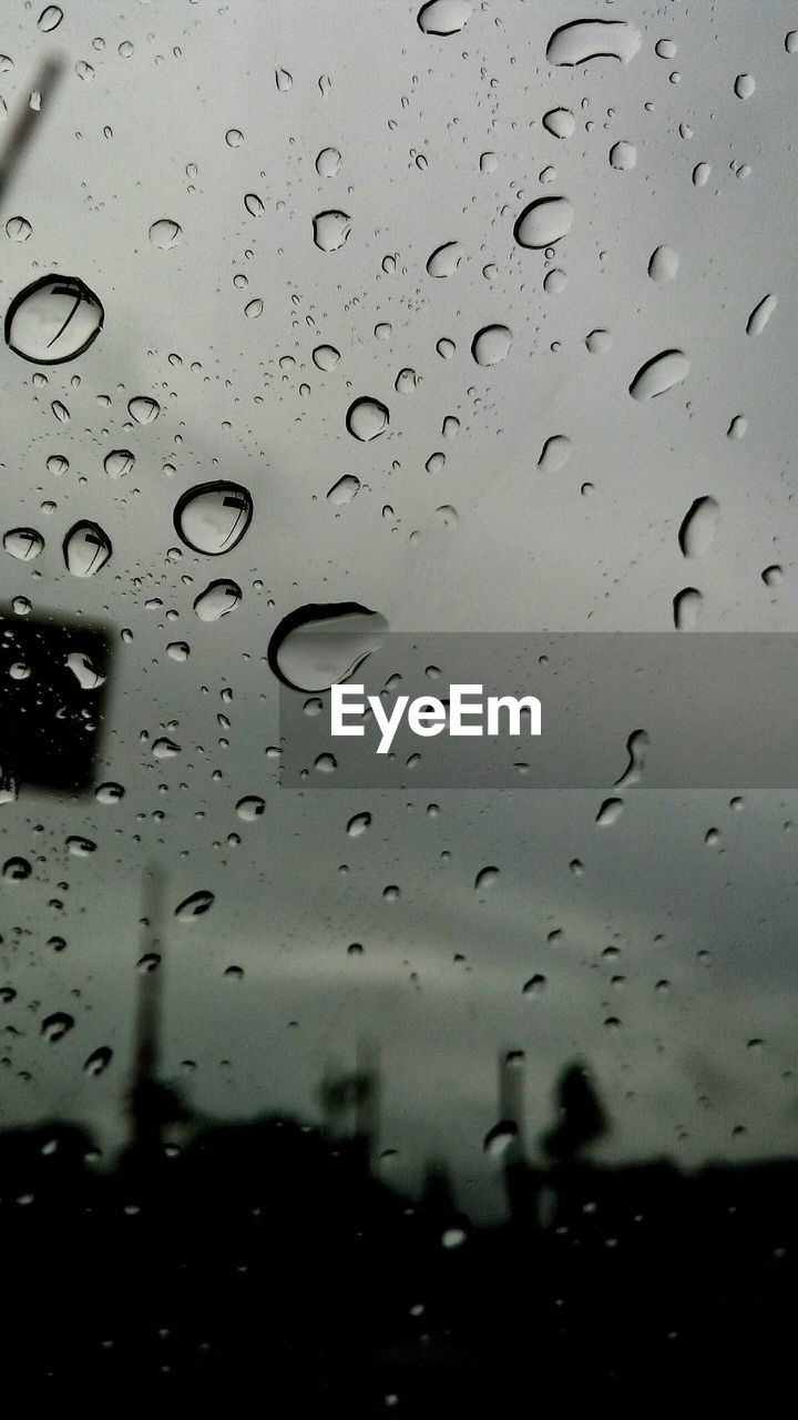 CLOSE-UP OF WET RAINDROPS ON WINDSHIELD