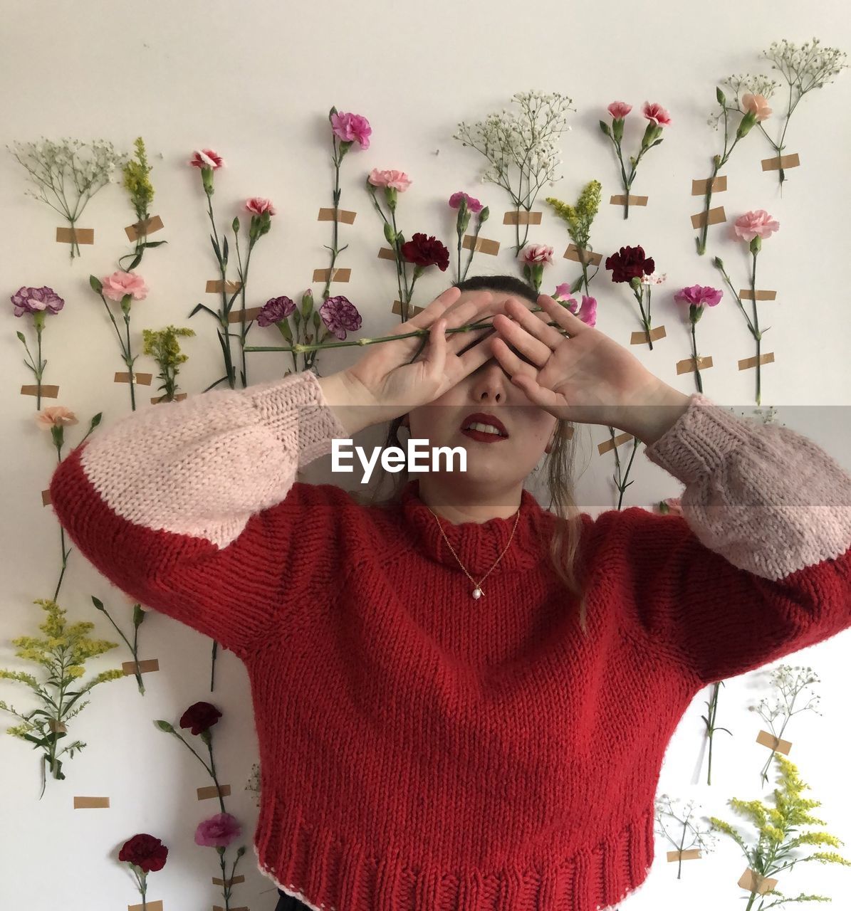 Portrait of beautiful young woman with red flowers