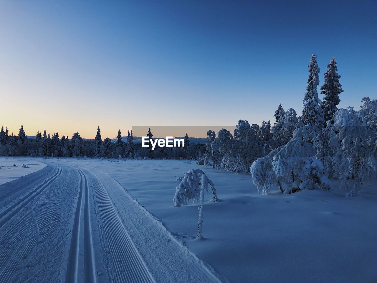 PANORAMIC VIEW OF SNOW COVERED LAND AGAINST CLEAR SKY