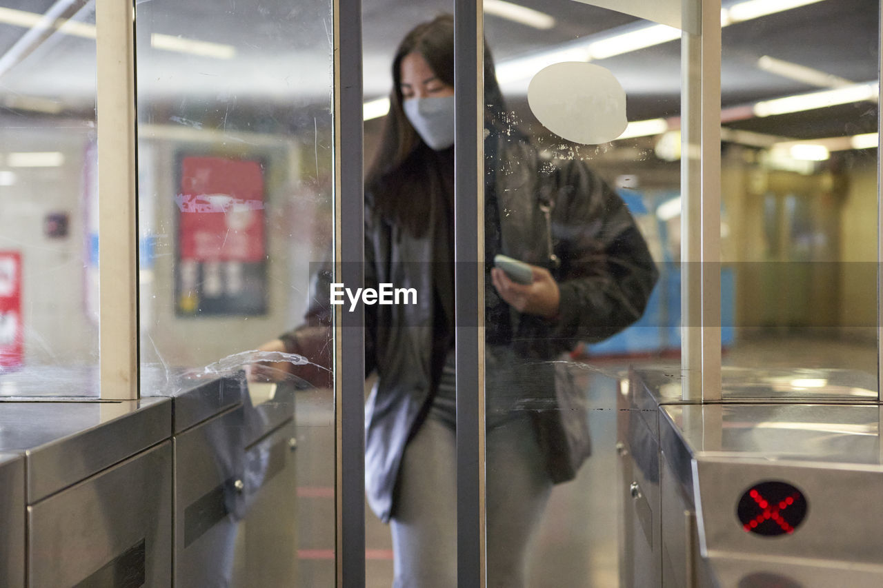 Young woman standing at turnstile in railroad station