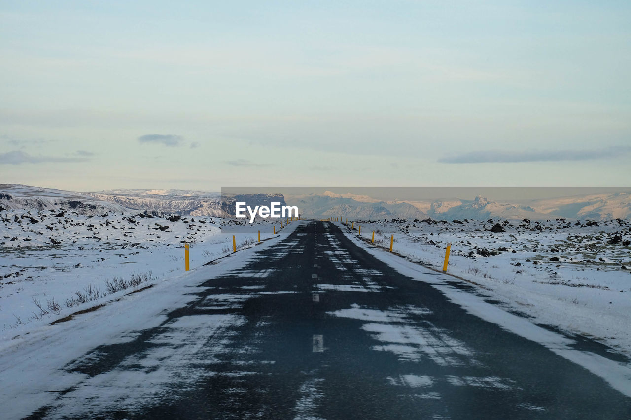Scenic view of road through landscape during winter