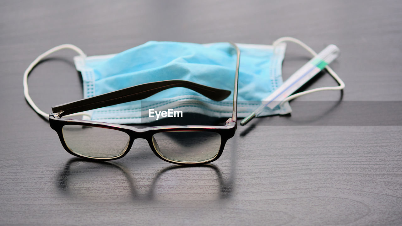 CLOSE-UP OF EYEGLASSES ON TABLE WITH UMBRELLA