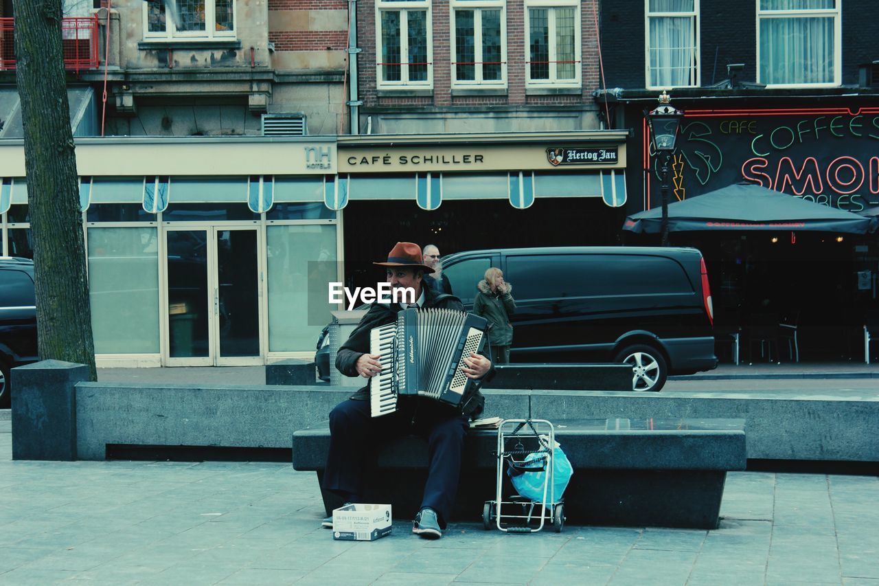 FULL LENGTH OF MEN STANDING IN FRONT OF BUILDING