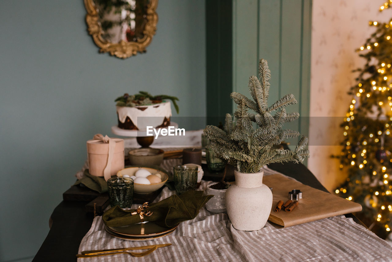 Festive decor of the dining table for christmas with a cake on the background of lights