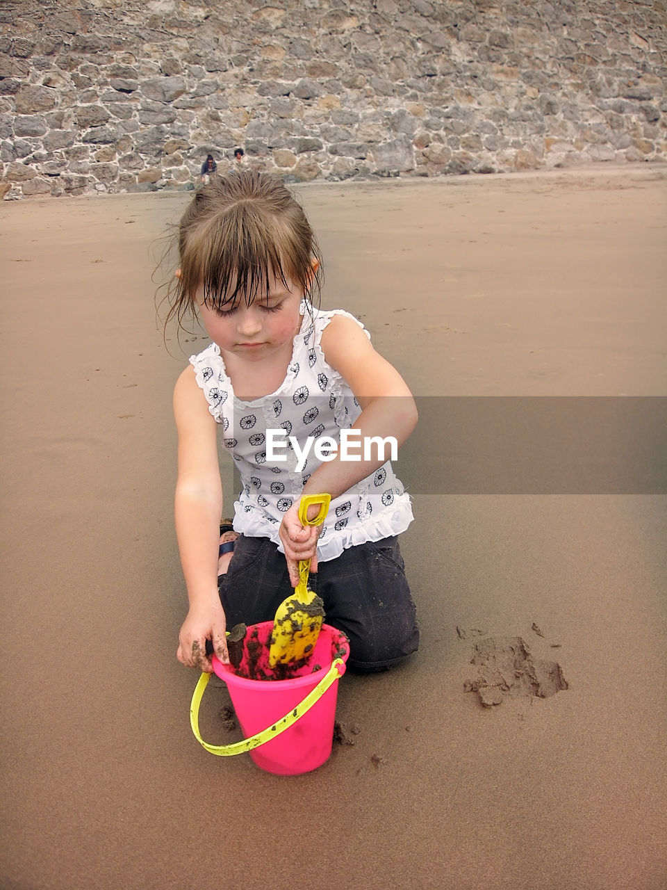High angle view of girl playing with toys and sand at beach