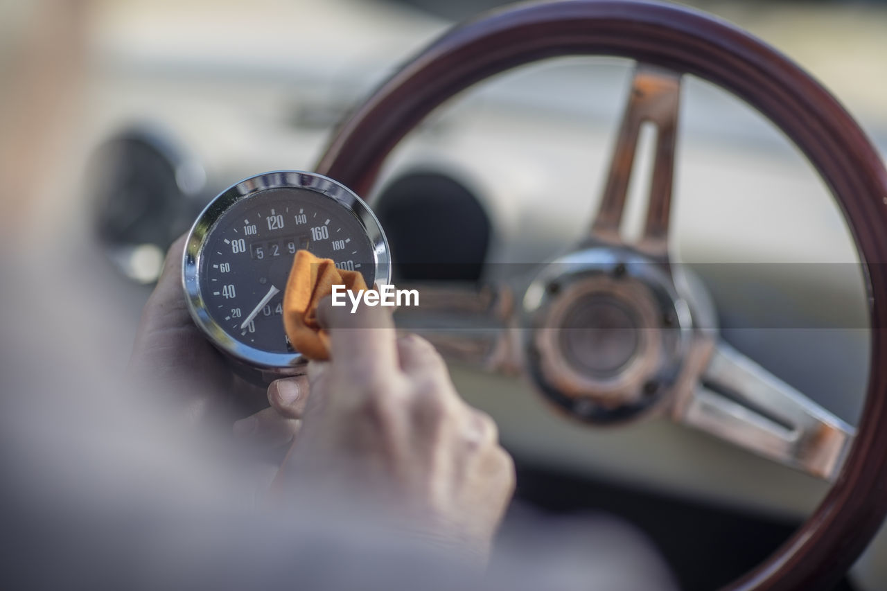 Senior man polishing tachometer of a car