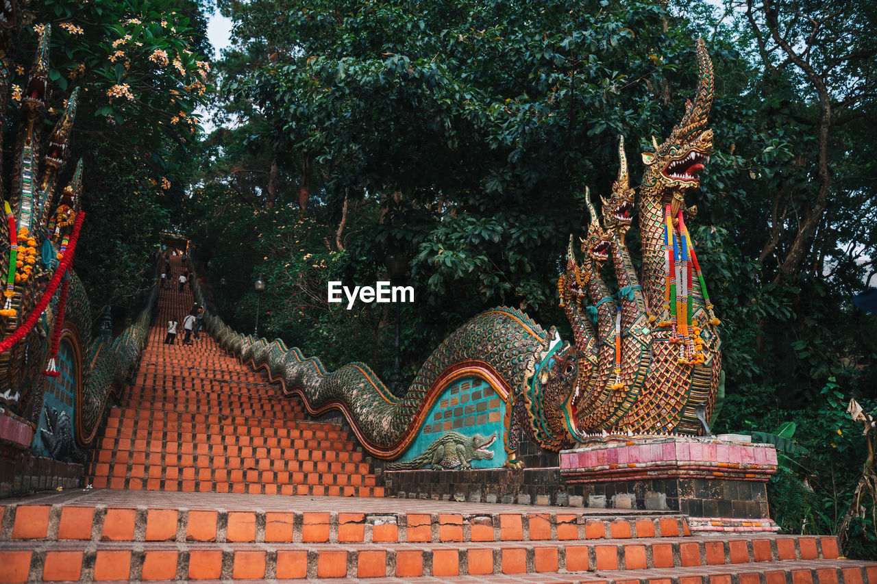 LOW ANGLE VIEW OF STATUE AGAINST TEMPLE