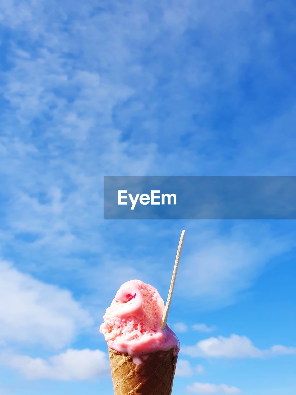 Close-up of ice cream cone against sky